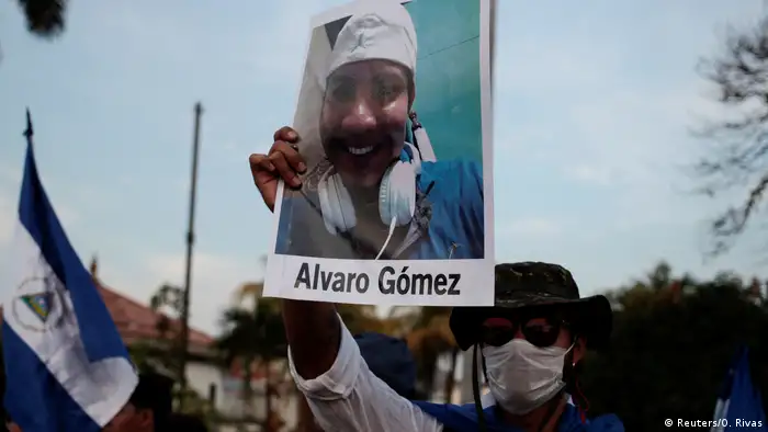Manifestante levantando un cartel con la fotografia de Alvaro Gomez