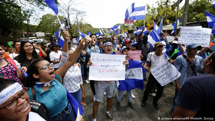 Estudiantes gritando consignas con pancartas y banderas de Nicaragua durante una marcha