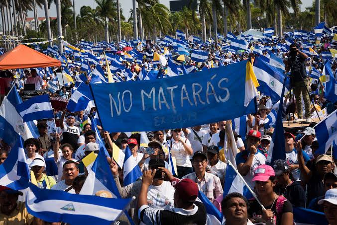 Multitud con banderas de Nicaragua y una manta con la frase No matarás