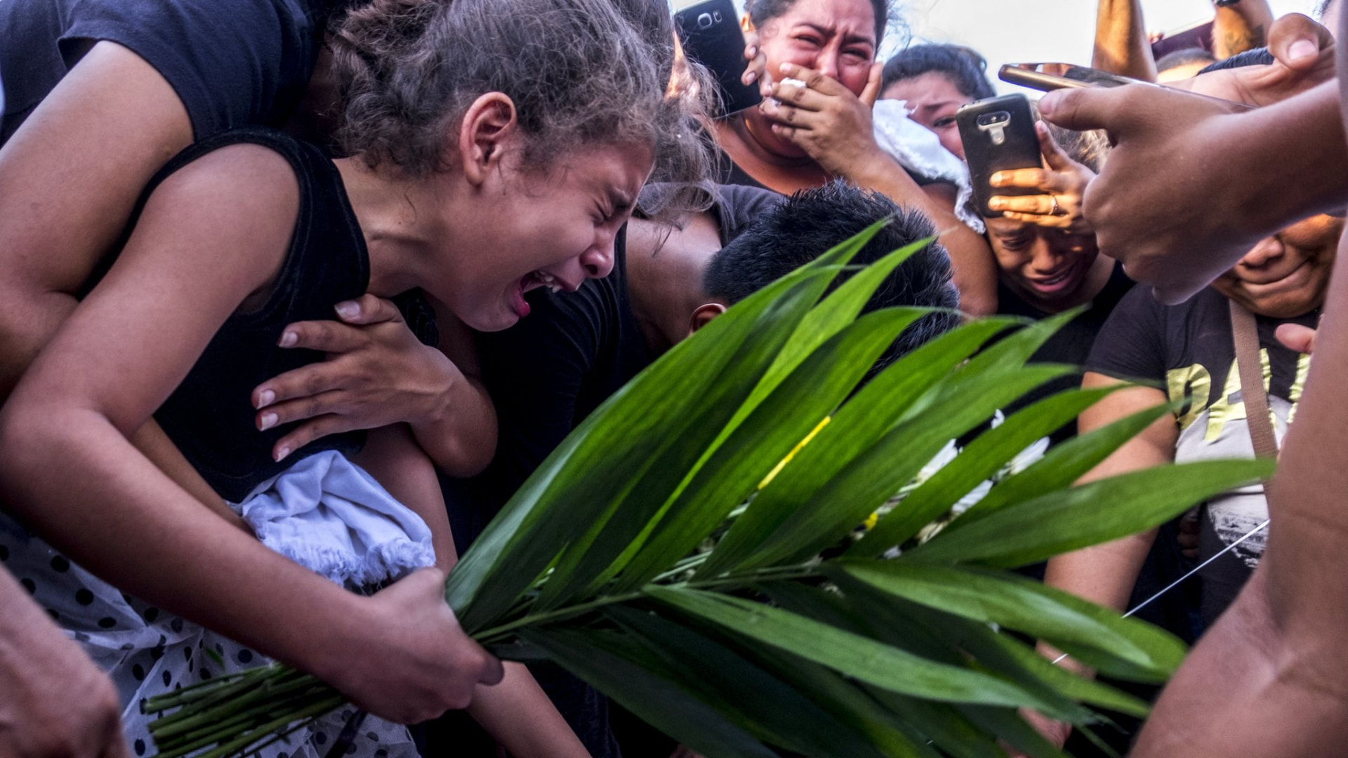 Jóvenes llorando durante el funeral de una víctima de la represión en Nicaragua